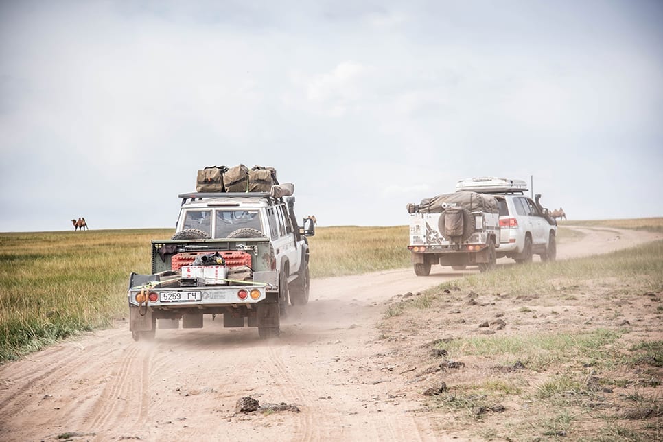 4WD vehicles driving on an offroad dirt track with camping gear