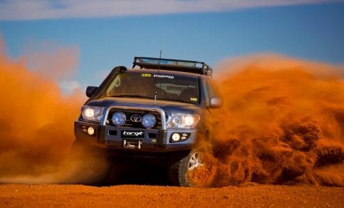 Toyota LandCruiser kicking up red dirt during the Finke Desert Race with Torqit exhaust upgrade