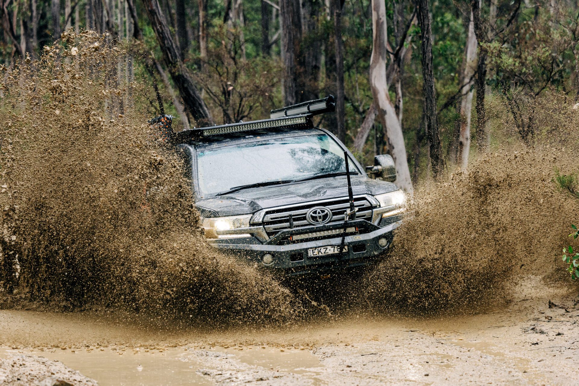 Toyota LandCruiser driving through deep mud on Captain Fawcett Track, Western Australia.