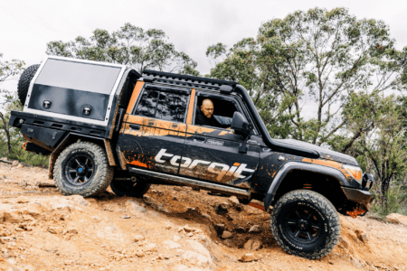 Toyota 79 Series LandCruiser upgraded with Torqit performance parts driving off-road on rocky terrain