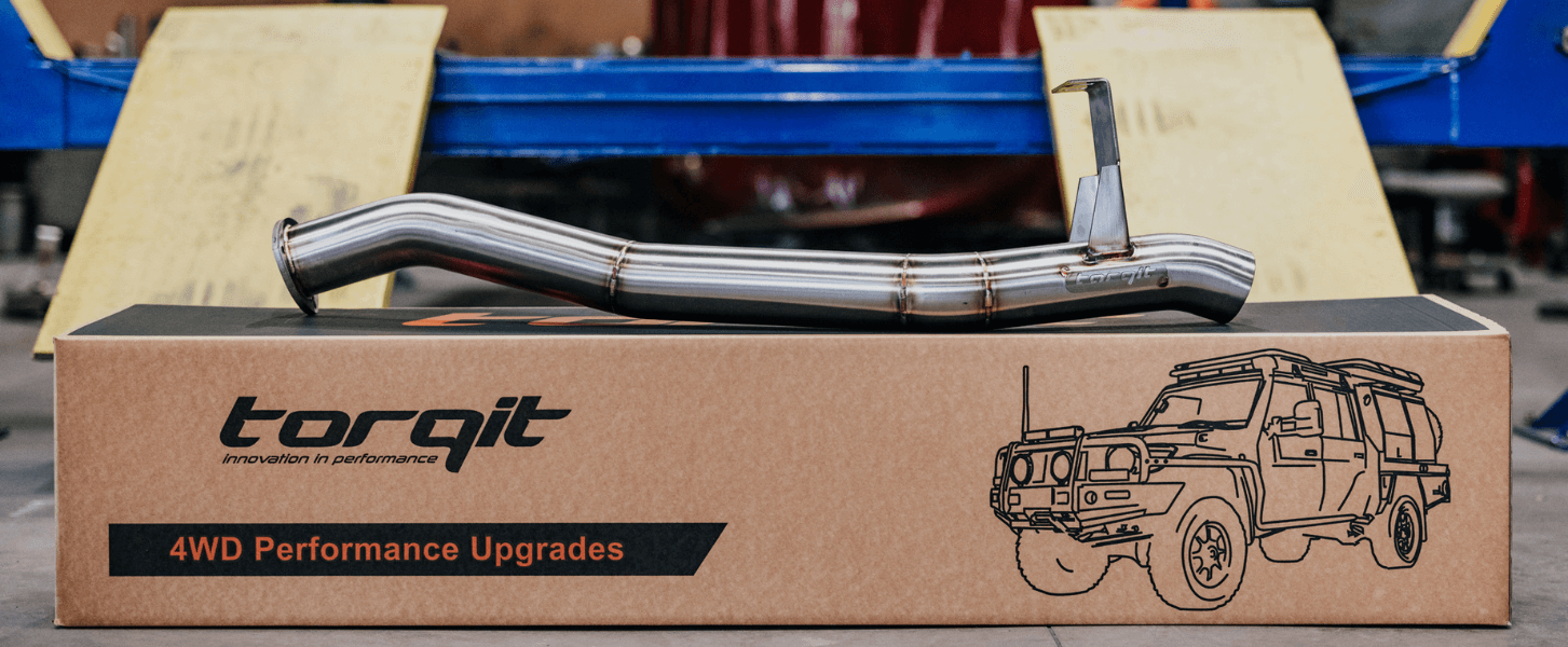 Stainless steel 4WD exhaust system displayed on a Torqit packaging box