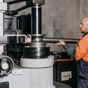 Technician operating Torqit’s mandrel bender to shape an exhaust pipe.