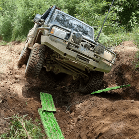 4WD fitted with Torqit exhaust climbing rocky offroad terrain with recovery boards