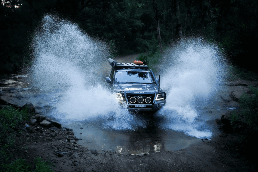 Nissan Y62 Patrol driving through deep water crossing with Torqit accessories