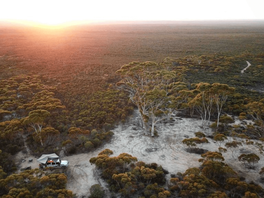 4WD camping setup at sunset on the Holland Track, Western Australia, surrounded by Aussie bushland and iconic scenery.