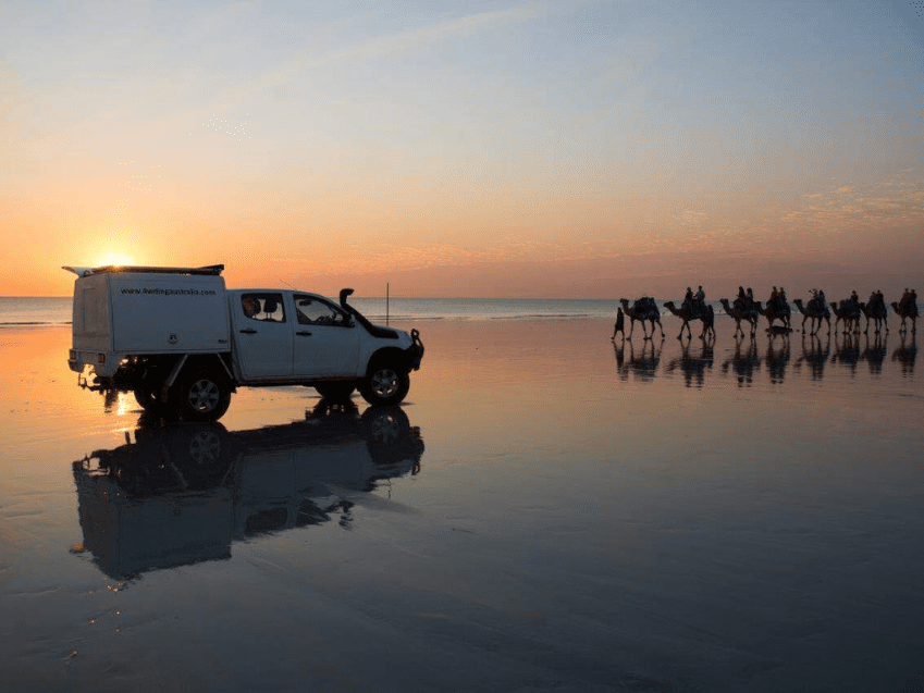 4WD on Cable Beach at sunset with camel caravan, Broome WA