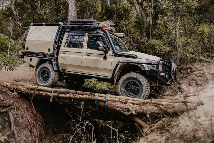 Toyota LandCruiser LC79 crossing a log bridge during an off-road adventure