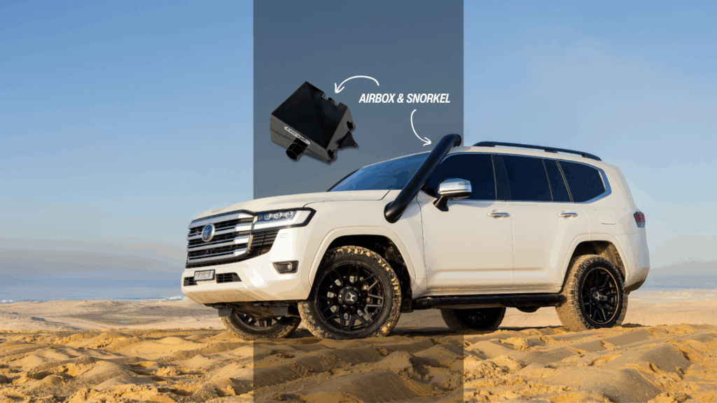 White Toyota LandCruiser fitted with Torqit snorkel and airbox driving through sandy desert terrain.