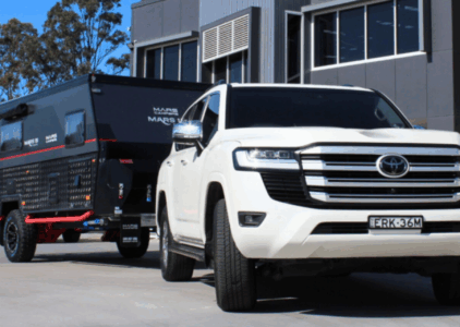 White Toyota Land Cruiser 300 towing a caravan outside Torqit Performance Centre.