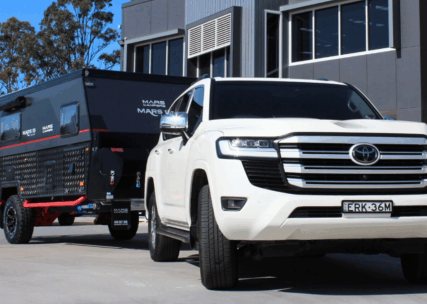 White Toyota Land Cruiser 300 towing a caravan outside Torqit Performance Centre.